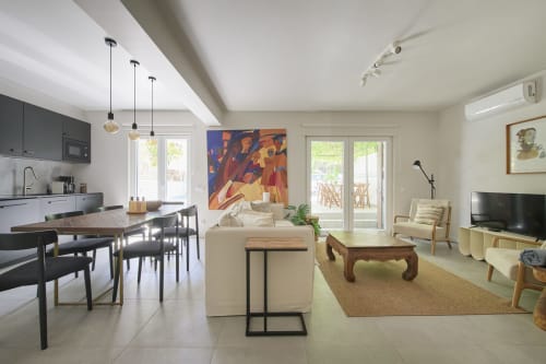 Villa moderna con espacios abiertos de estar, comedor y cocina, mobiliario confortable, arte y vista a la piscina