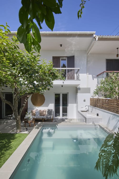 Moderna villa blanca en Republica do Sul con piscina turquesa, zona de descanso y exuberante jardín en Aroeira
