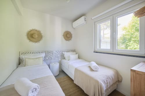 Luminoso dormitorio doble en Republica do Sul con aire acondicionado, ropa de cama blanca, arte decorativo en las paredes y vistas al jardín desde amplios ventanales