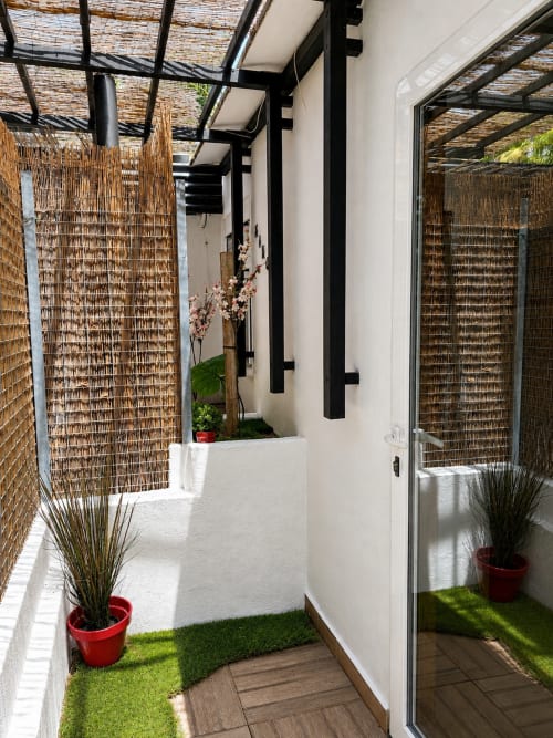 Modern patio with woven screens, potted plants, and wooden decking at Apartamentos Turísticos Axarent, Almayate Alto