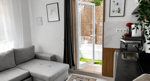 Modern living room with gray sofa and patio doors opening to sea view at Apartamentos Turísticos Axarent, Almayate Alto
