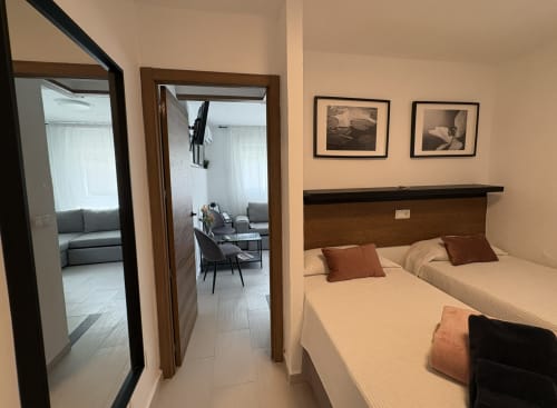 Modern bedroom with twin beds, brown headboard, and en-suite in Almayate Alto beachfront apartment