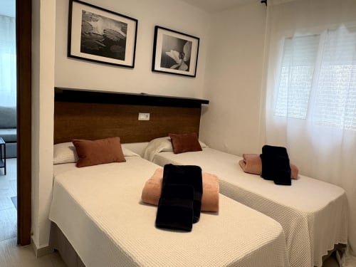 Twin beds with beige linens and rust cushions in Apartamento 3 Playa Almayate, Almayate Alto