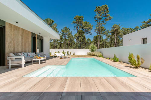 Villa moderna com piscina turquesa, deck de madeira e pinheiros na República do Sul em Aroeira, Portugal