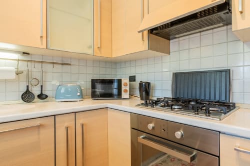 Moderne Küche im Apartment Casa Pleiadi am Prince Garda, Sirmione mit Gaskochfeld, Mikrowelle und weißer Fliesenrückwand