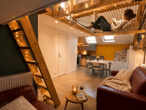 Studio loft moderne au gîte de Chaparon à Lathuile : canapé cuir, échelle bois, cuisine et mezzanine couchage.