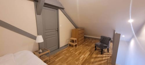 Chambre mansardée à la Villa Varco à Auxonne avec parquet, plafond incliné et mobilier minimaliste