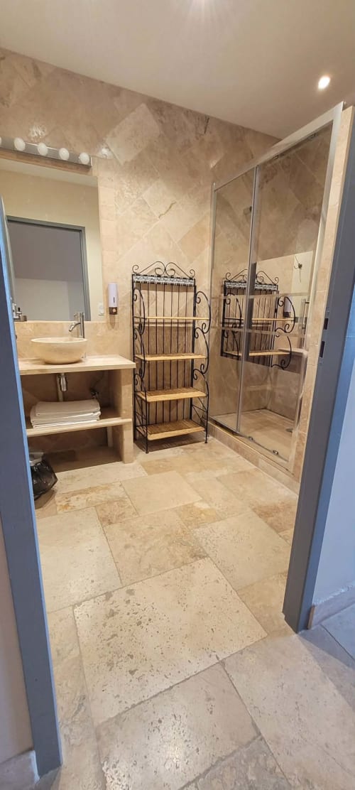 Salle de bains luxueuse à la Villa Varco à Auxonne : carrelage marbre, meuble-lavabo et douche à l'italienne.
