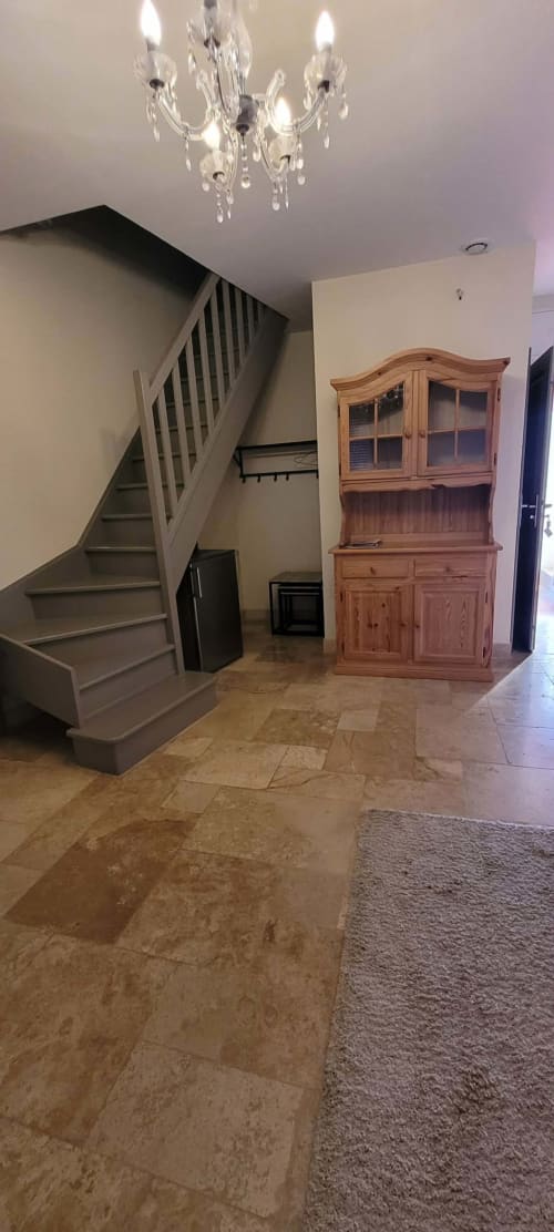 Élégant vestibule de la Villa Varco à Auxonne avec escalier, lustre, meuble en bois et carrelage