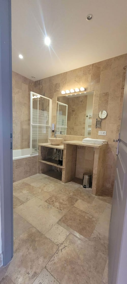 Salle de bains moderne de la Villa Varco avec carrelage en travertin, double vasque, douche à l'italienne et sèche-serviettes électrique