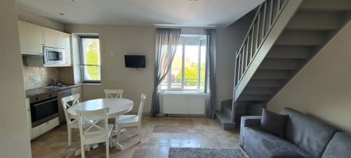 Suite familiale Villa Varco à Auxonne avec cuisine ouverte, salle à manger, séjour et escalier donnant sur la ville