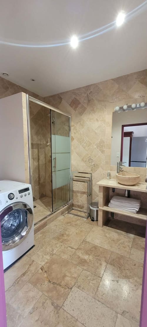Modern bathroom in Villa Varco's Suite familiale with stone tiling, walk-in shower, vessel sink, and washing machine, Auxonne