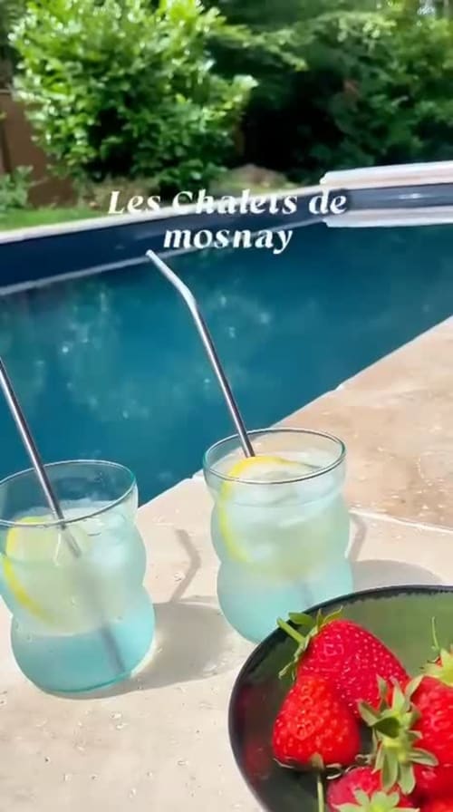 Poolside refreshments at Les Chalets de Mosnay: chilled drinks with lemon and fresh strawberries by the pool