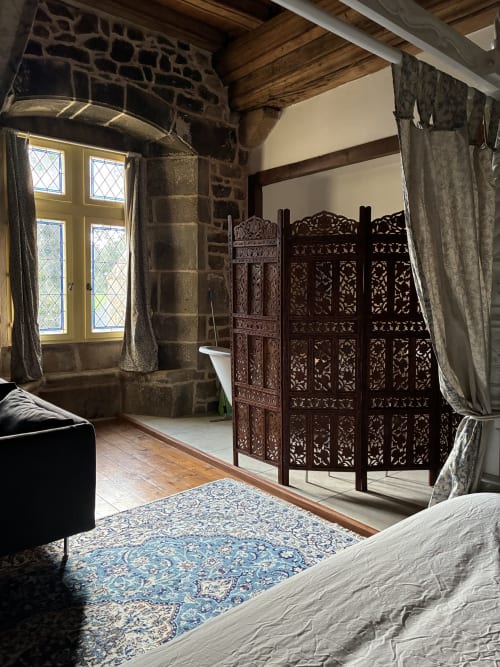 Chambre Royale du Manoir de Fornebello avec paravent en bois ouvragé, mobilier d'époque et fenêtres à treillis donnant sur