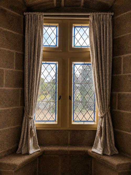 Portes vitrées au plomb avec rideaux ouvrant sur la vue du jardin au Manoir de Fornebello, Bretagne