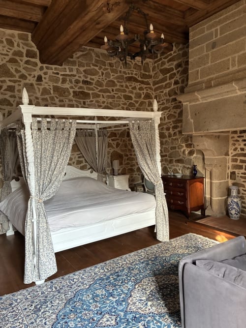 Lit à baldaquin élégant aux rideaux motifs dans la Chambre Royale du Manoir de Fornebello, murs de pierre et boiseries