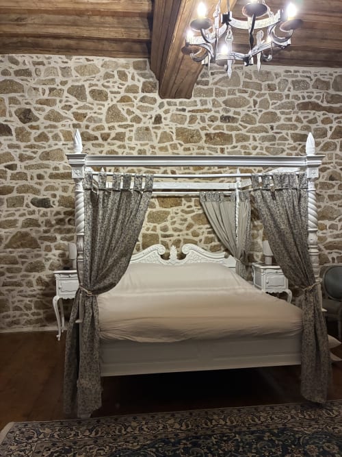 Lit à baldaquin luxueux aux rideaux drapés dans la Chambre Royale aux murs de pierre du Manoir de Fornebello, Châtelaudren-Plouagat