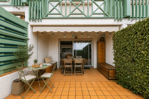 Terrasse face mer à La Loge Du Bassin à Cap Ferret avec table de salle à manger, transats et vue sur l'océan par portes vitrées.