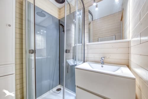 Salle de bains moderne avec douche à l'italienne, vasque blanche et murs en bois clair à La Loge Du Bassin, Lège Cap Ferret