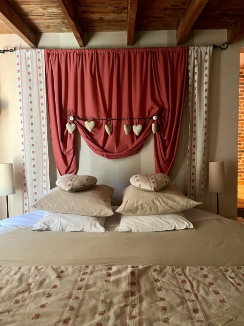 Lit à baldaquin luxueux aux tentures rouges et décors de cœurs à la Domaine De La Ferme De Ribeaufontaine, Dorengt