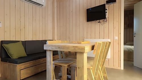 Salle à manger de la villa Verlaine aux Chalets Du Lac avec table en bois, chaises, canapé et téléviseur mural à Marange-Silvange