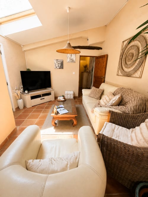 Salon confortable du Gîte Lavande à Forcalquier avec canapé accueillant et téléviseur