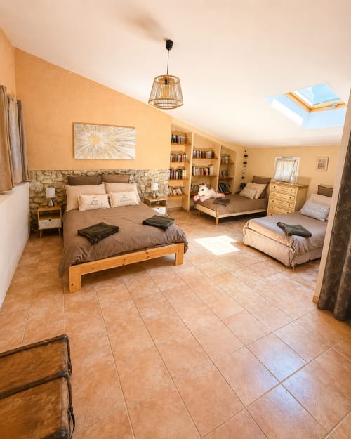 Spacieuse chambre du Gîte Lavande au Domaine Bellavigne à Forcalquier, avec sol en terre cuite et ambiance chaleureuse