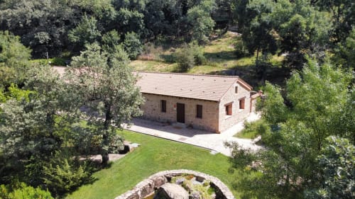 Rústica casita de piedra rodeada de olivos y césped verde en El Escondite De Pedro Malillo, Candeleda