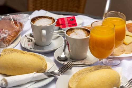 Continental breakfast spread at Hotel Balcón De Los Montés with croissants, cappuccino, orange juice, bread and cheese in