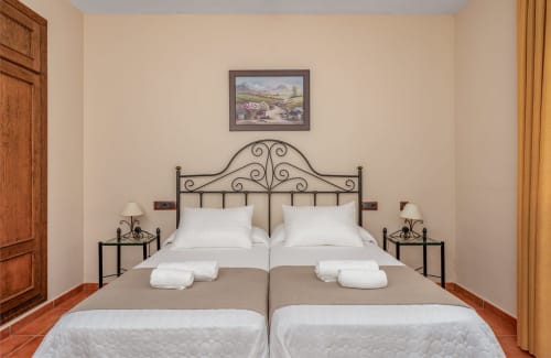 Spacieuse chambre double avec tête de lit en fer forgé, literie blanche et vue sur la ville à l'Hôtel Balcón De Los Montés à Colmenar