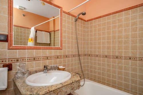 Salle de bain moderne à l'Hôtel Balcón De Los Montés à Colmenar avec lavabo blanc rond, carrelage terre cuite et douche