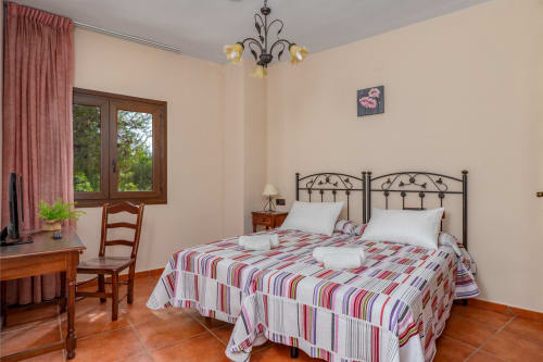 Chambre accessible à l'Hôtel Balcón De Los Montés à Colmenar avec lits jumeaux, carrelage terre cuite et vue sur le jardin
