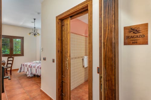 Chambre d'hôtel accessible à l'Hôtel Balcón De Los Montés à Colmenar avec portes en bois, carrelage en terre cuite et vue sur la chambre