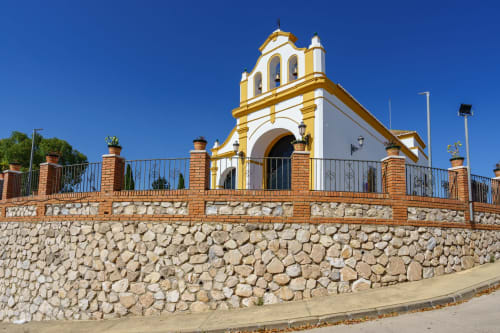 Chapelle de l'Hôtel Balcón De Los Montés aux façades blanches et dorées, dominant Colmenar en Espagne