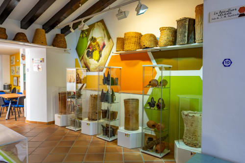 Exposition muséale avec paniers tissés, outils agricoles et artefacts historiques à l'Hôtel Balcón De Los Montés à Colmenar,