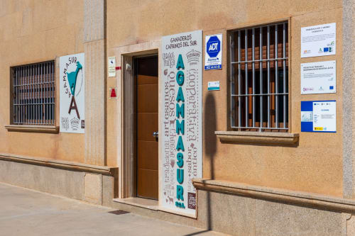 Entrée extérieure du restaurant Hotel Balcón De Los Montés à Colmenar avec porte en bois et grilles de sécurité