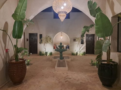 Cour du Riad Arkaya à Essaouira avec architecture traditionnelle, fontaine centrale, lanterne ornée et plantes vertes luxuriantes