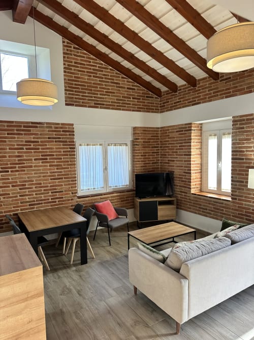 Sala de estar estilo loft moderno en El Escondite De Pedro Malillo en Candeleda con ladrillos expuestos, vigas en techo y