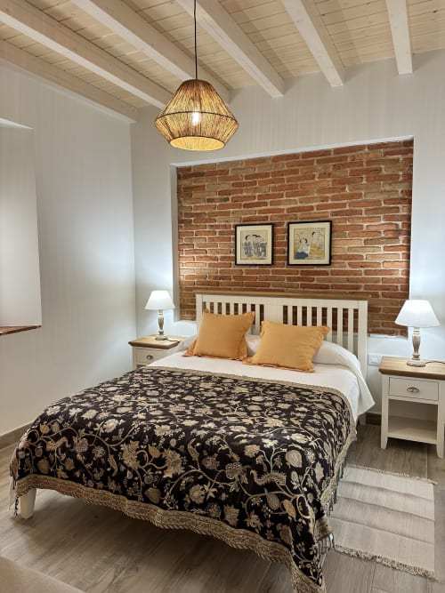 Acogedora habitación en El Escondite De Pedro Malillo, Candeleda con pared de ladrillo visto, vigas de madera y detalles dorados