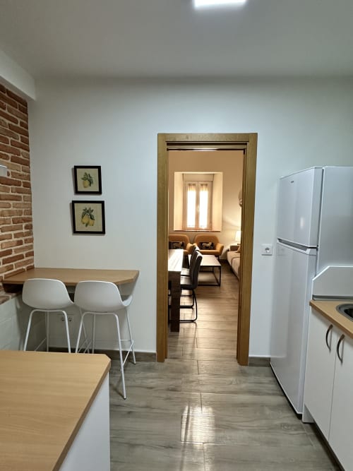 Cocina moderna con electrodomésticos blancos, encimeras de madera y comedor en El Escondite De Pedro Malillo, Candeleda
