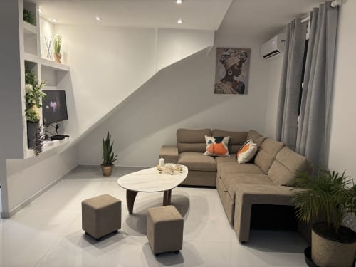 Séjour moderne du gîte Cythère au Domaine De Marly avec canapé en L beige, table basse en marbre blanc et