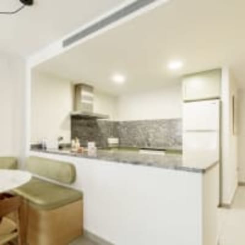 Cocina moderna del apartamento Racons en Vic con gabinetes blancos, encimeras grises y vistas a la ciudad