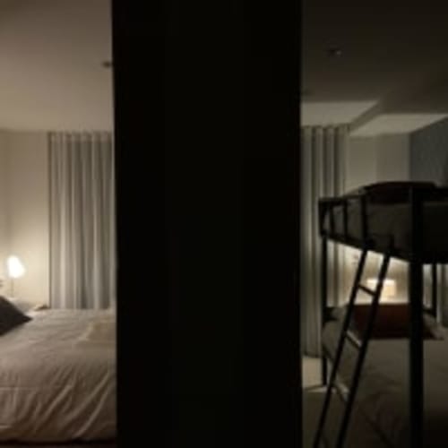 Dormitorio del apartamento Racons en Vic con vistas a la ciudad, cama, cortinas, sillón y mobiliario moderno