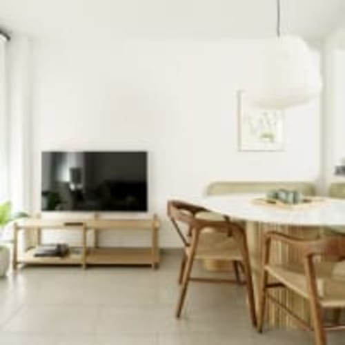 Sala de estar del apartamento Racons Placeta con televisión, sillas de comedor de madera y cocina en Vic