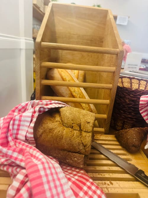 Wooden bread box with fresh baked bread and pink checkered cloth at Hotel Verdi in Jesolo