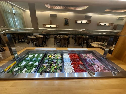 Salad bar with fresh vegetables at Verdi hotel in Jesolo, featuring greens, tomatoes, mozzarella, and beetroot in metal