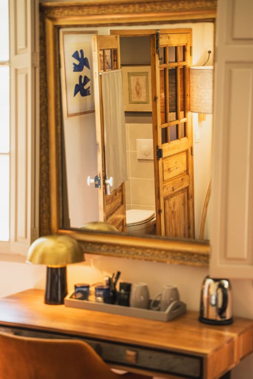 Miroir de salle de bain aux Jardins de Baracane, Avignon, avec mobilier en bois et articles de toilette