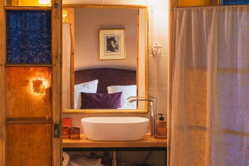 Salle de bain luxueuse de la chambre Les Jardins de Monet aux Jardins de Baracane, Avignon, avec baignoire ovale et équipements modernes