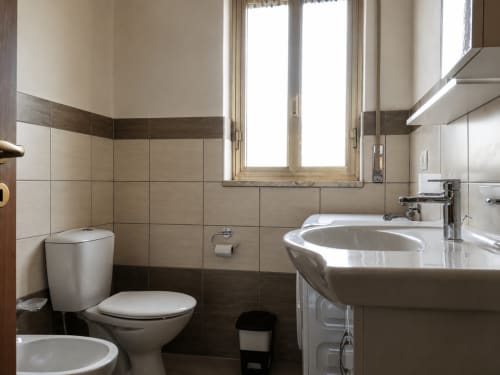 Moderno bagno di Villa Leuka San Lorenzo a Noto con rivestimenti in piastrelle, wc e lavabo curvo