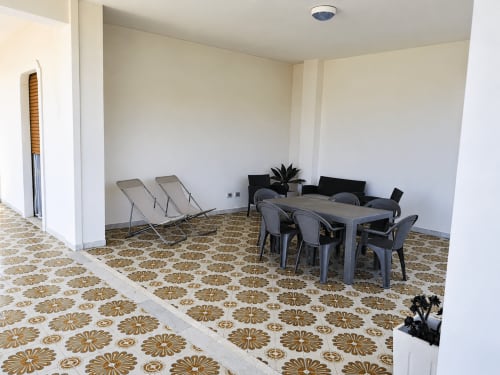 Ampia zona pranzo di Villa Leuka San Lorenzo, Noto con pavimento in piastrelle decorate, tavolo da pranzo, sedie e area lounge